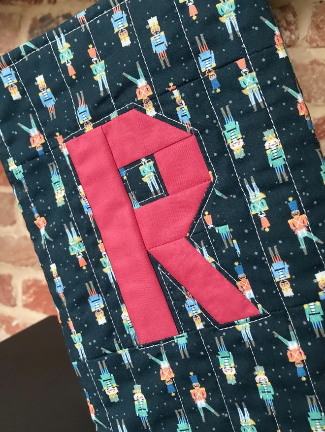 Close Up of Cooper and Fred Toy Soldier Quilted Personalised Christmas Stocking with Brick Red Letter