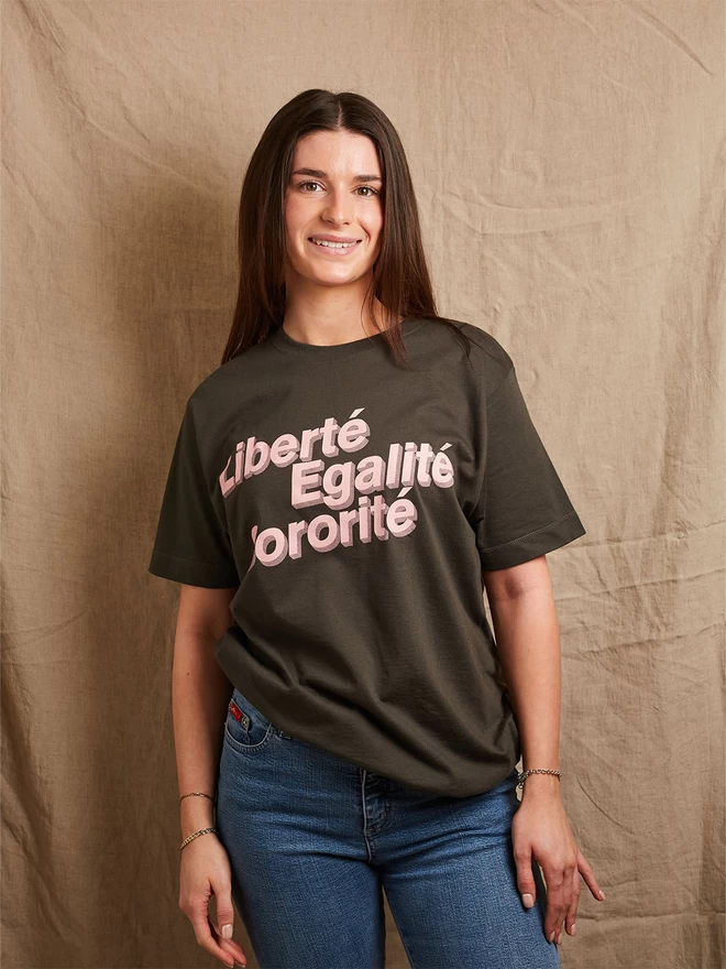 Model is wearing a charcoal grey cotton t-shirt with the slogan Liberté, Egalité, Sororité in pale pink written on the front