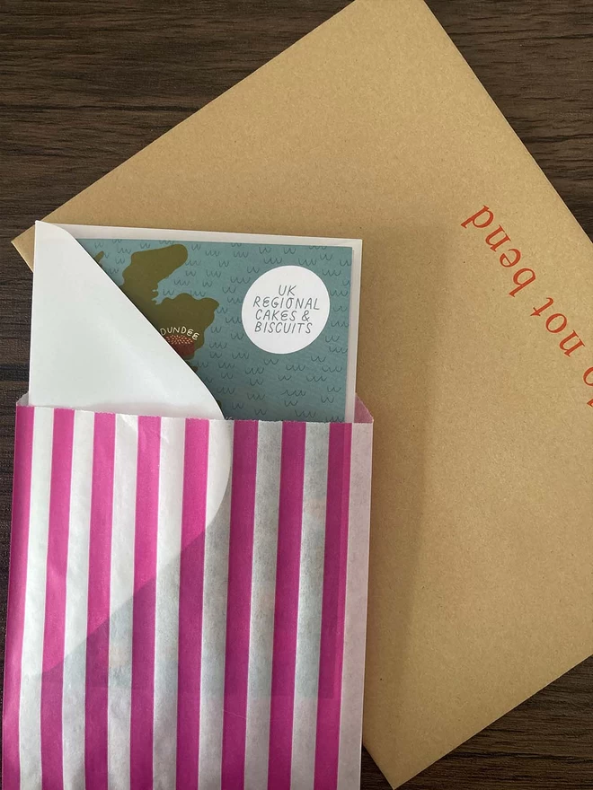 Card packed with envelope into striped paper bag