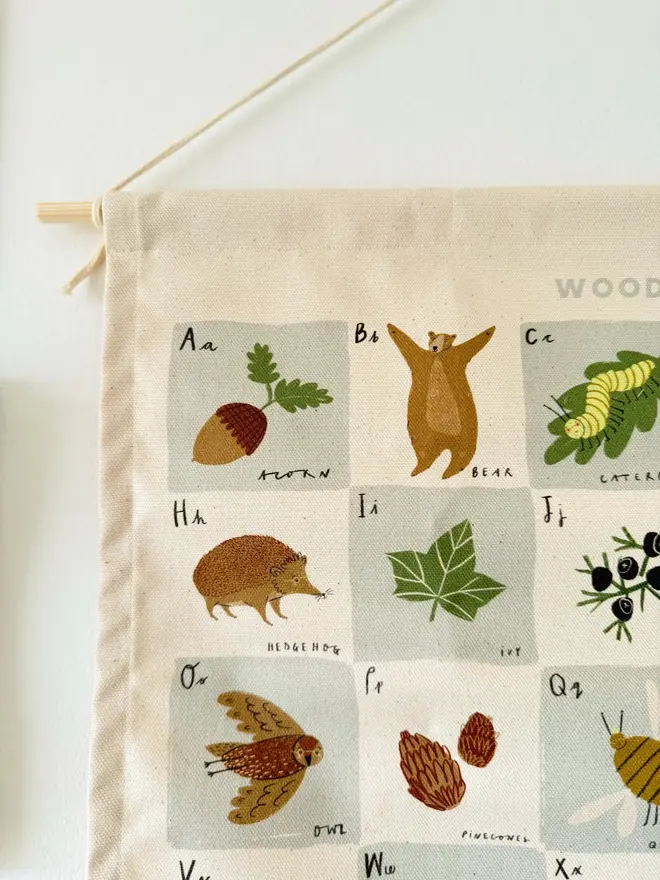 Woodland Alphabet Fabric Banner, hanging on a white wall. 