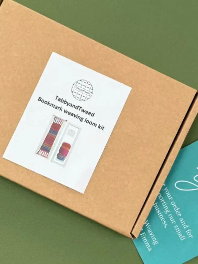 Cardboard box with an image in the kit on a white sticker, on a green background. 