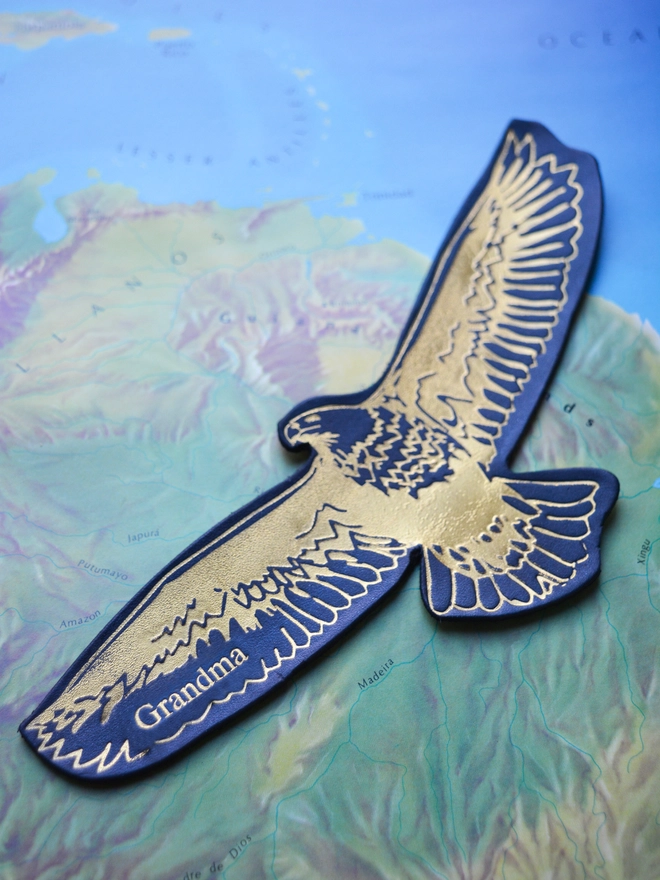 a navy blue leather eagle bookmark in gold illustration embossed by natthakur made from Italian vegetable tanned leather and personalised with the word grandad
