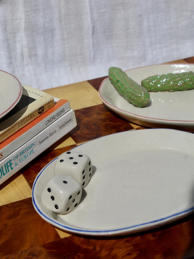 Still Life Trinket, a collection of trinkets sitting on a plate on a wooden surface.  Dish