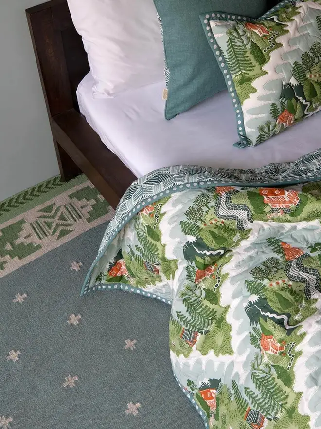 Manali Flatweave Rug, a colourful rug sitting in a bedroom. It is accompanied by other colourful furniture. 