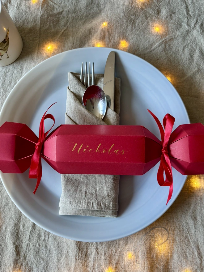 Bright red cracker with red ribbons and gold calligraphy 