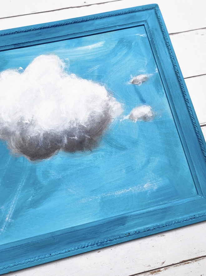 large cloud painting in turquoise painted directly onto a frame
