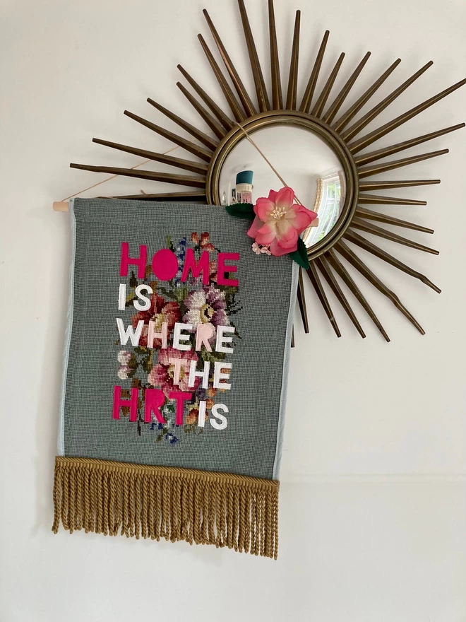 Tapestry pennant with the words 'Home is where the HRT is' on it