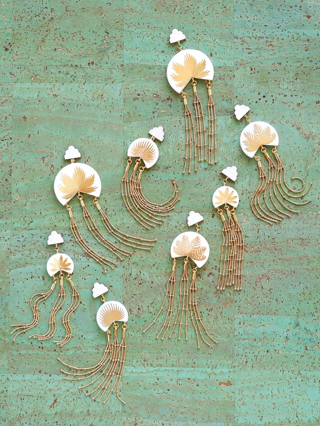 Macao gold palm tree print tassel earrings in 4 sizes on green cork background