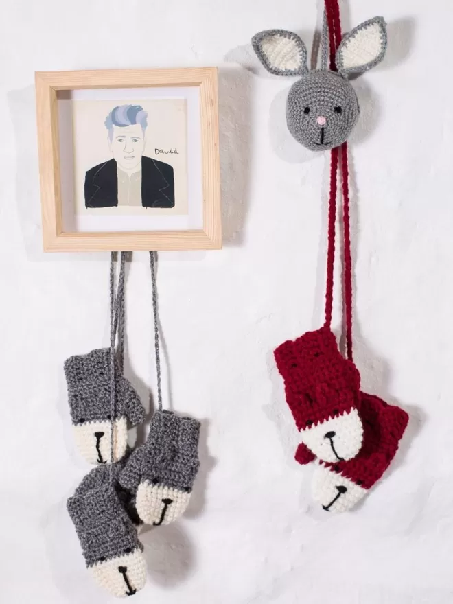 EKA Animal Mittens seen hanging on a wall.