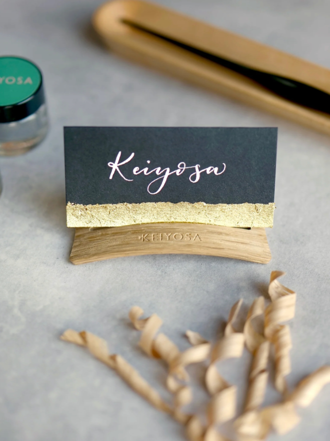 Arch Place Card Holder. Keiyosa’s place card holder with a dark and gold card inside.