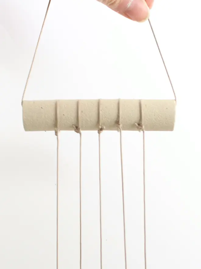 Close up of raw clay ceramic bar at the top of the hanging decoration