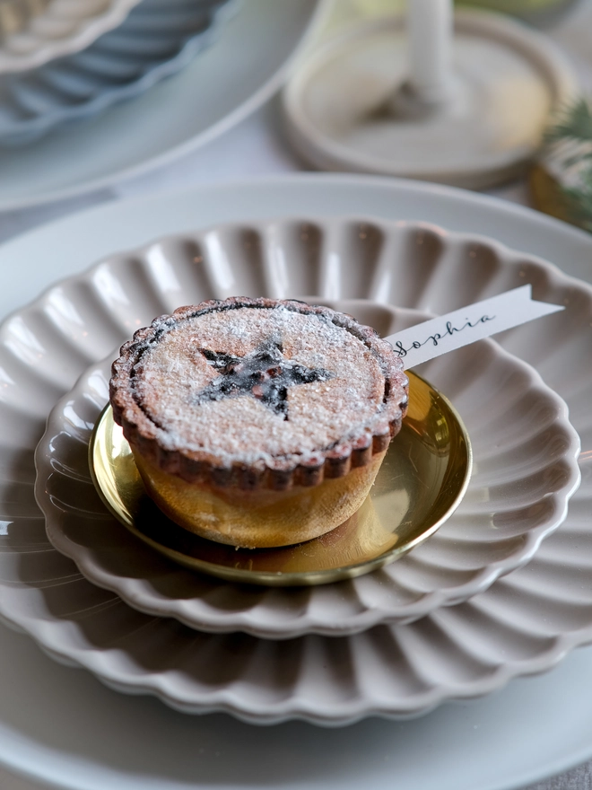 A festive handpainted wooden mince pie place setting with handwriten note to welcome your guests at the Christmas table