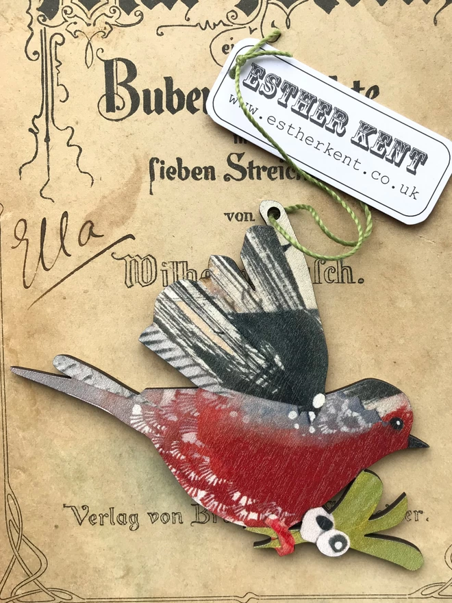 An illustrated Robin decoration rests on a vintage book cover