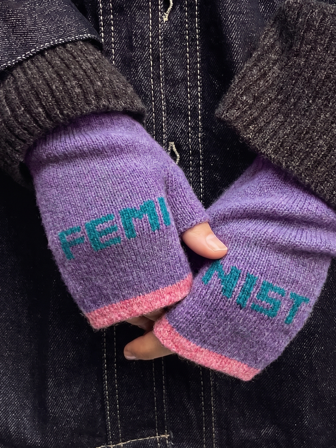 Lifestyle image of Violet & Teal Feminist Mittens worn with a tweed jacket