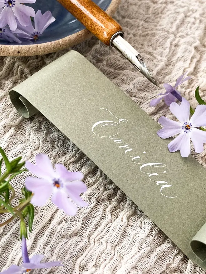 sage green scroll calligraphy wedding place cards. sage green scroll with white calligraphy.