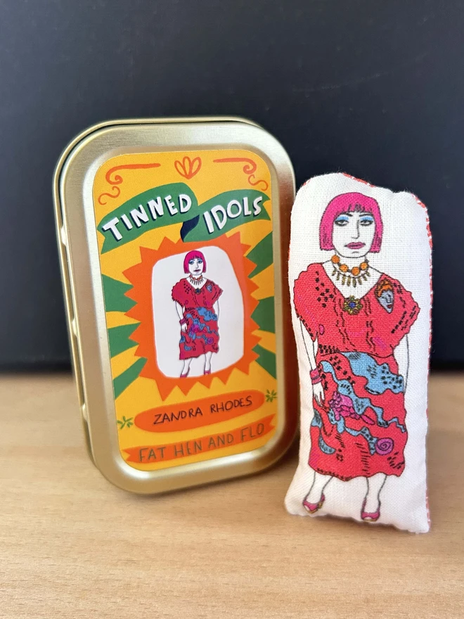 Mini illustrated fabric doll of British fashion and textile designer Zandra Rhodes in a keepsake tin.