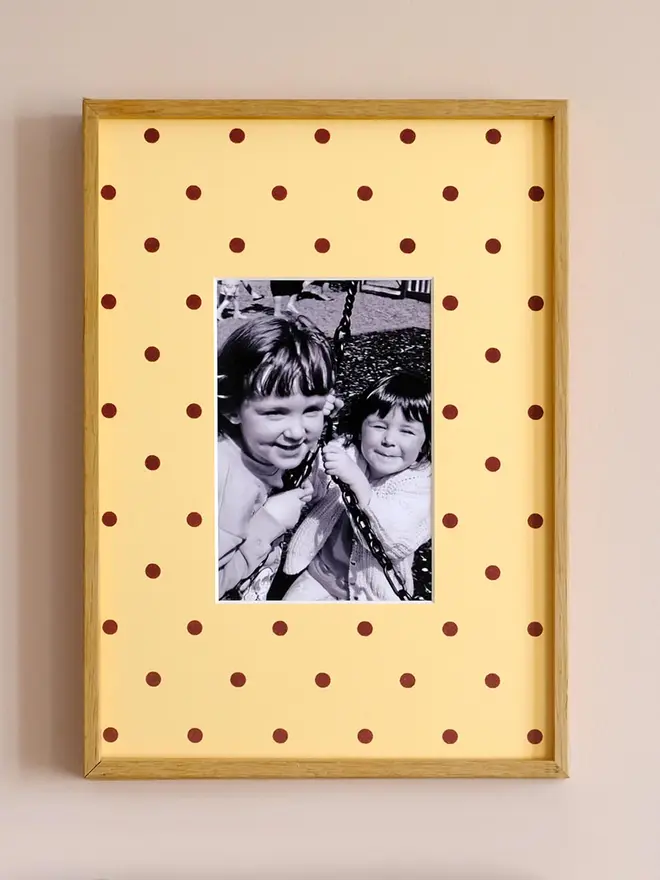 polka dot photo mount. a yellow polka dot mount in a frame with a childhood photo in the centre.