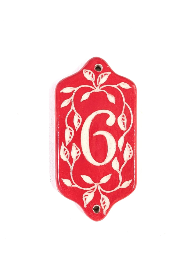 Red Sgraffito Leaf Address Tile. A tile with ‘6’.