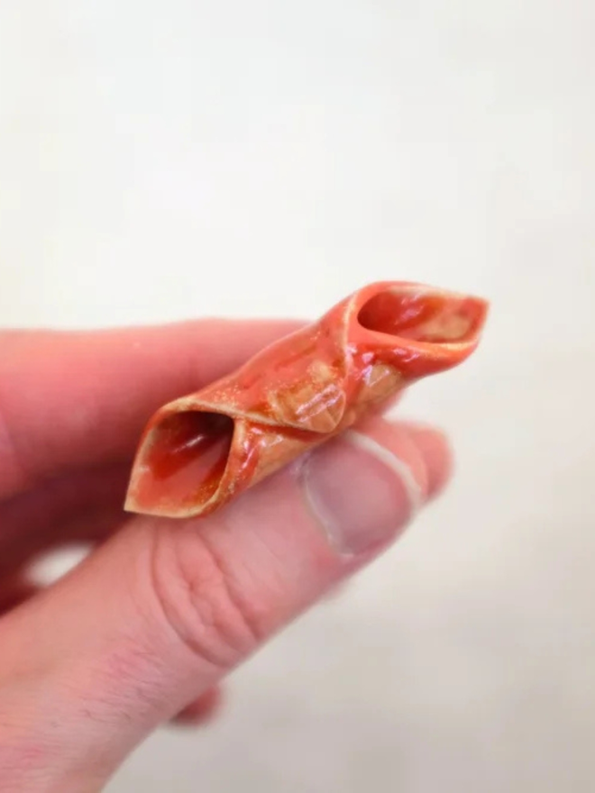 ceramic pasta magnet. a ceramic garganelli magnet on a fridge door.