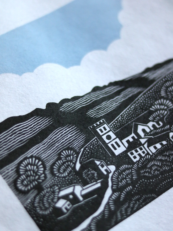 Original handmade linocut print featuring a Cornish village with a church, houses, fields and trees