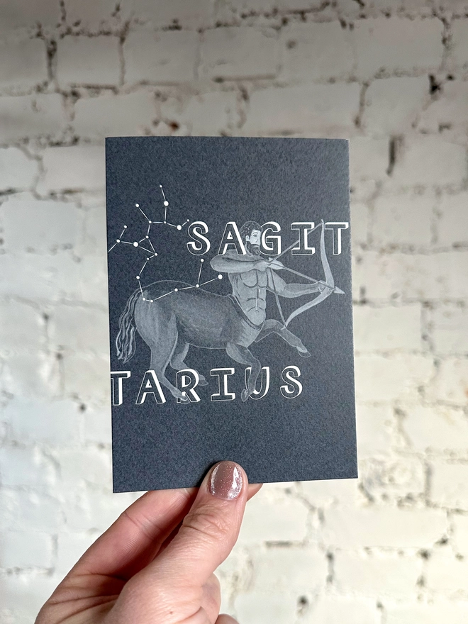 a greetings card featuring a greyscale illustration of a zodiac style centaur with the text “SAGITARIUS”