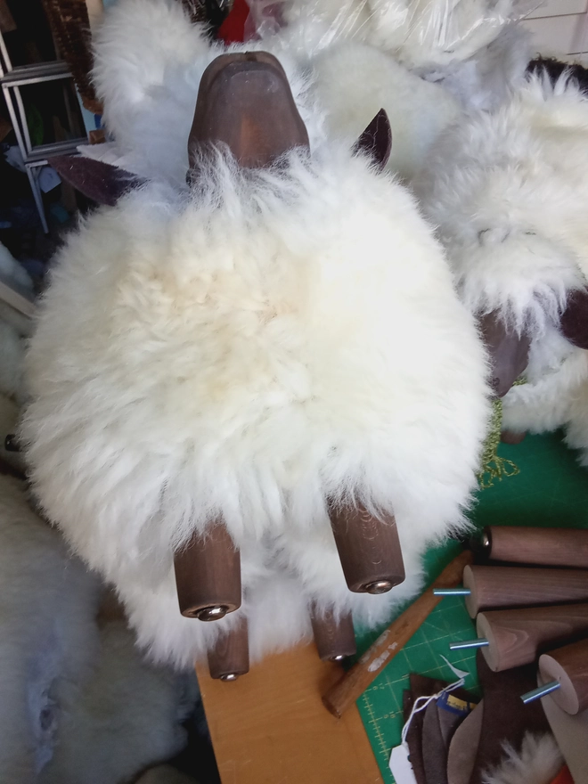 The underside of the footstool showing the wooden legs.