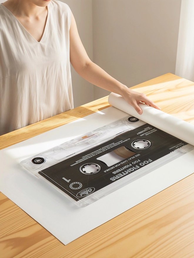 foo fighters cassette tape print. print being unrolled on wooden table.