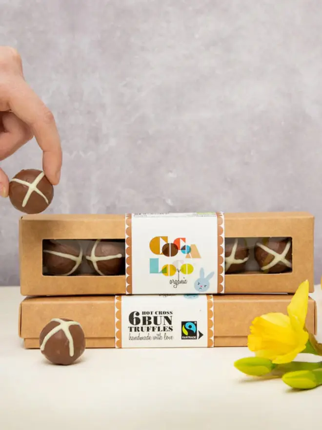Chocolate easter truffles in a box next to some daffodills