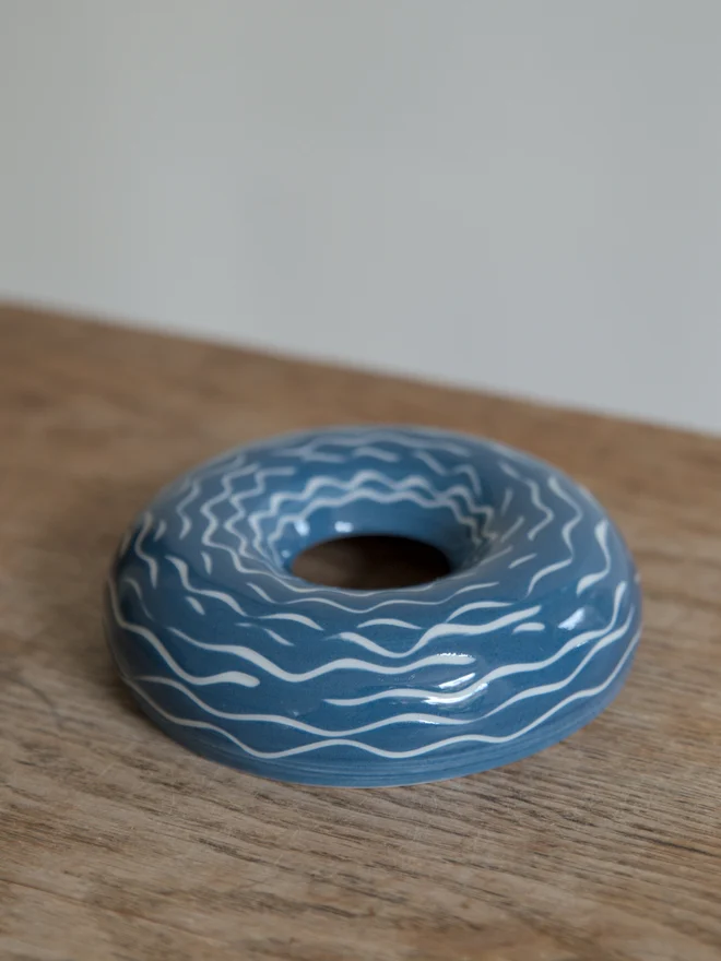 Handmade porcelain avocado planter with carved blue pattern, designed to hold an avocado seed for sprouting