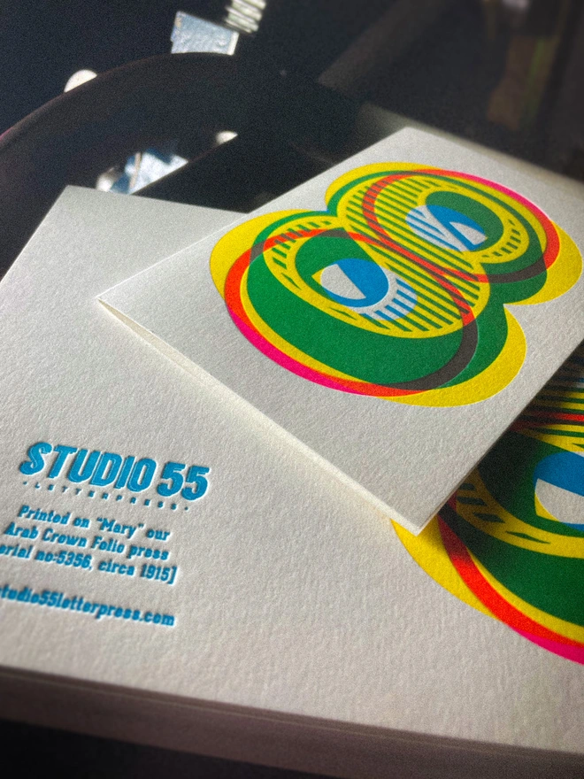 Handmade letterpress 8th birthday card featuring bold overlapping numerals printed in vibrant fluorescent cyan, magenta and yellow inks. Each card is individually hand printed using traditional letterpress techniques on luxury paper stock, creating a beautifully tactile finish with a deep impression and rich layered colours inspired by the CMYK printing process. Printed on a traditional letterpress from 1915. A wonderful artisan printed birthday card.