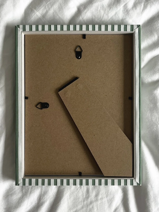 Green Vanguard Stripe Frame, the back of a colourful striped frame sitting on a plain white surface. 