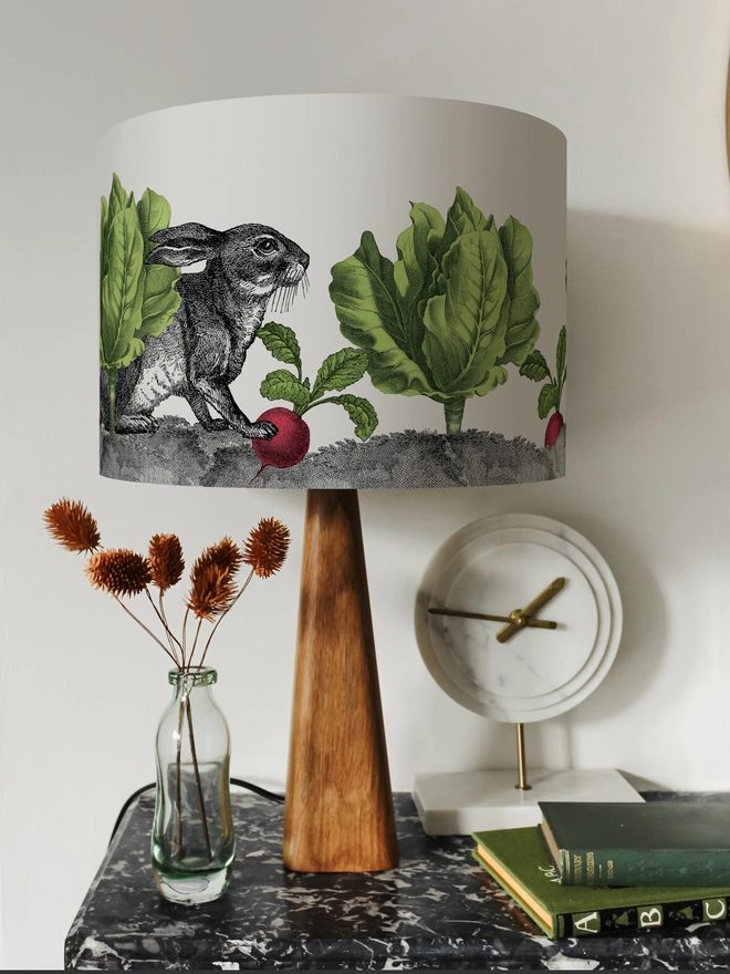 Mischievous rabbit lampshade handmade with vintage animal etchings, hiding among lettuces and radishes in a quirky country-style design. 