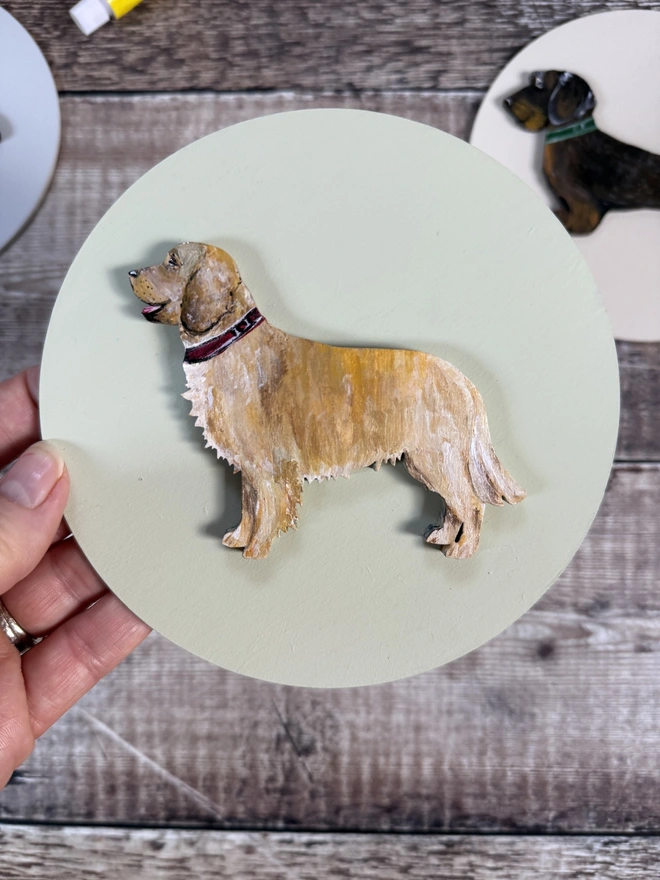 Hand Painted Golden Retriever dog Portrait mounted onto a circular wooden background also handpainted in pale pink 