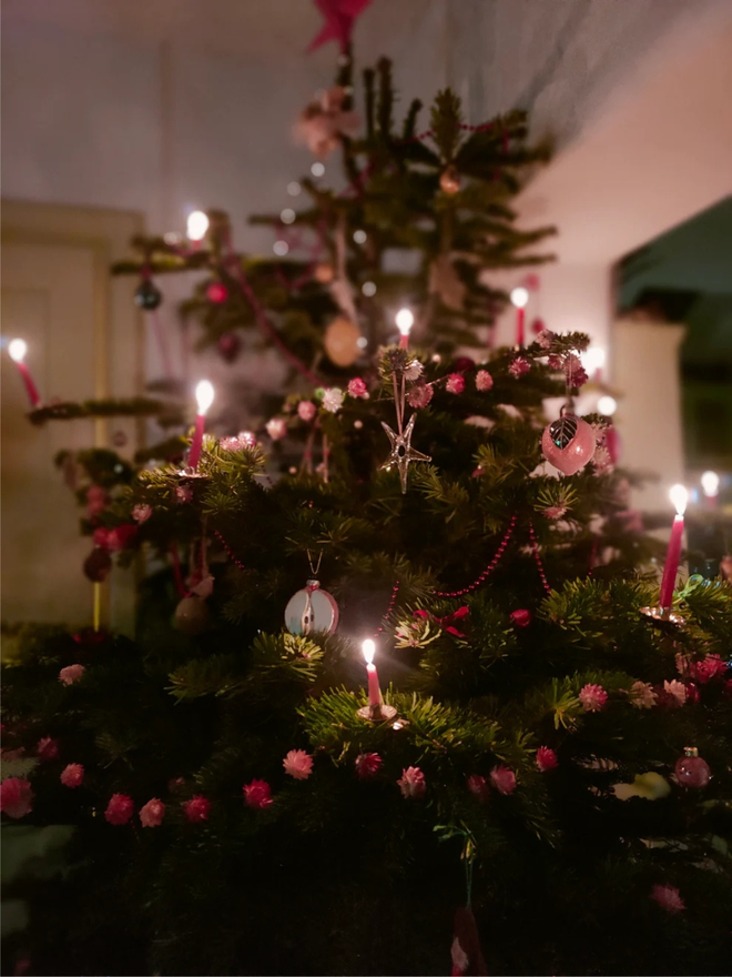 festive dried flower bud garland. pink dried flower garland hung on christmas tree. 