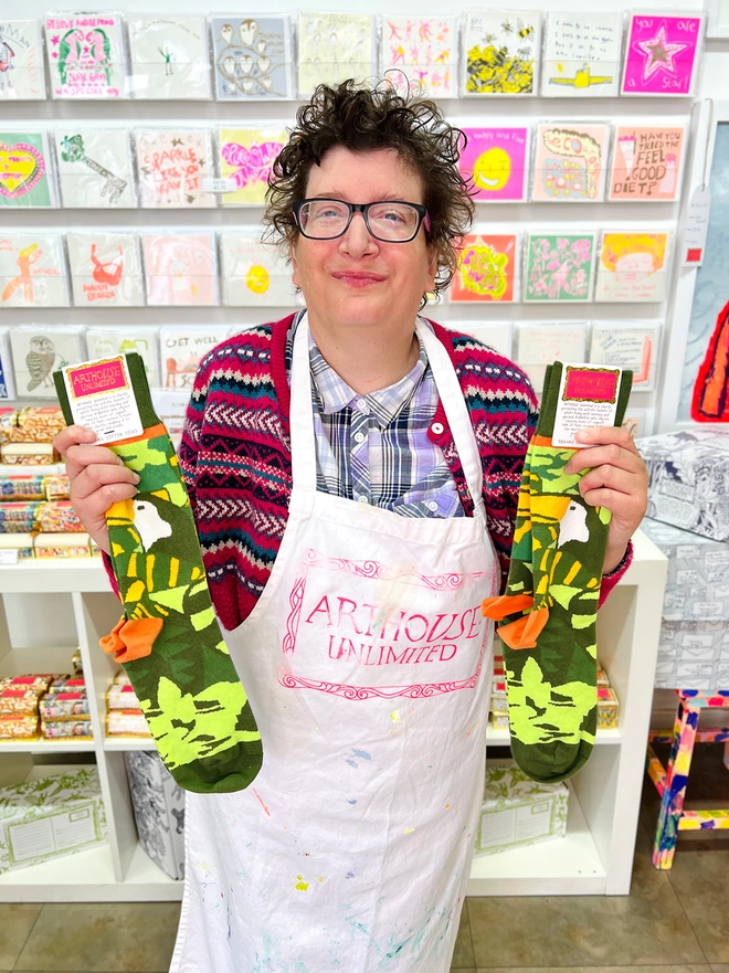 Happy artist holding amazon 100% organic charity cotton socks in green & yellow