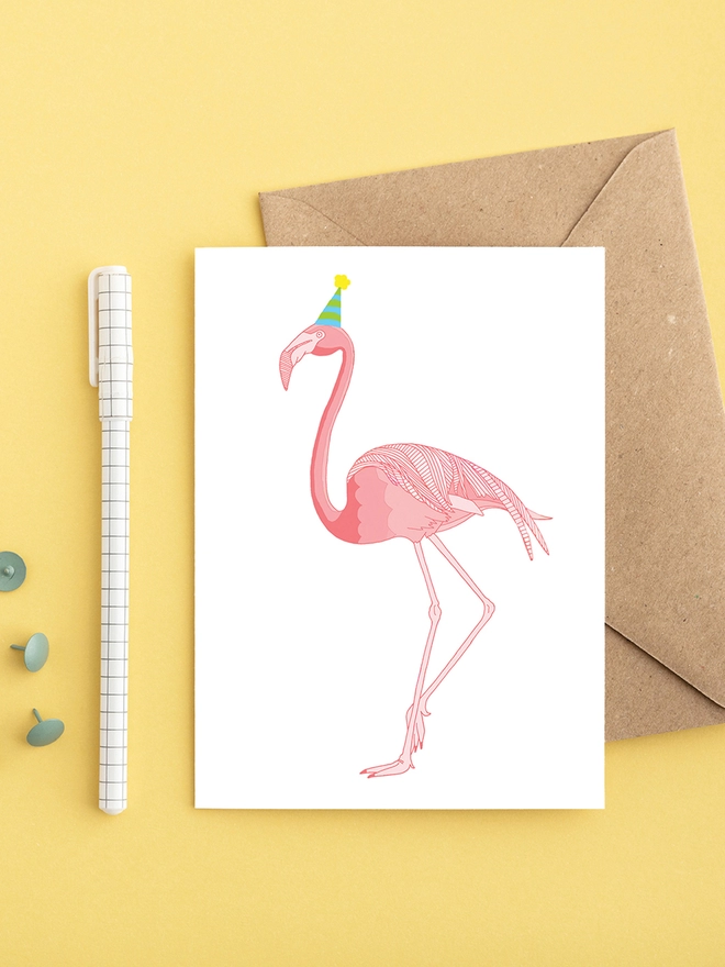 Bright greeting card featuring a flamingo in a hat