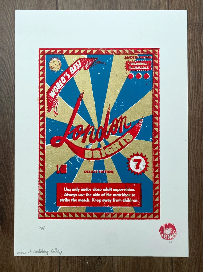 Bring a touch of nostalgic British charm to your space with this striking London Brights limited edition screen-print, inspired by the bold graphics of fireworks labels.     Featuring a vibrant palette of red, blue, and gold, the design showcases dramatic sunburst rays and retro typography, capturing the energy and character of classic mid-century advertising.      Each print includes the artist’s signature and edition number, this piece is perfect for lovers of London, vintage design, and unique statement art.