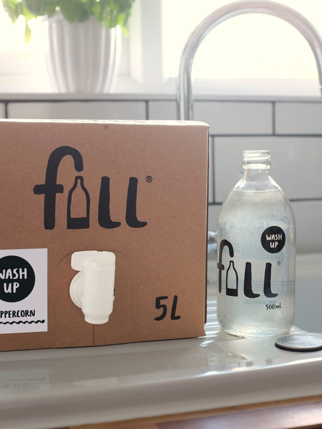 Washing up Liquid. A 5L refill box next to a 500ml bottle, both next to a sink.