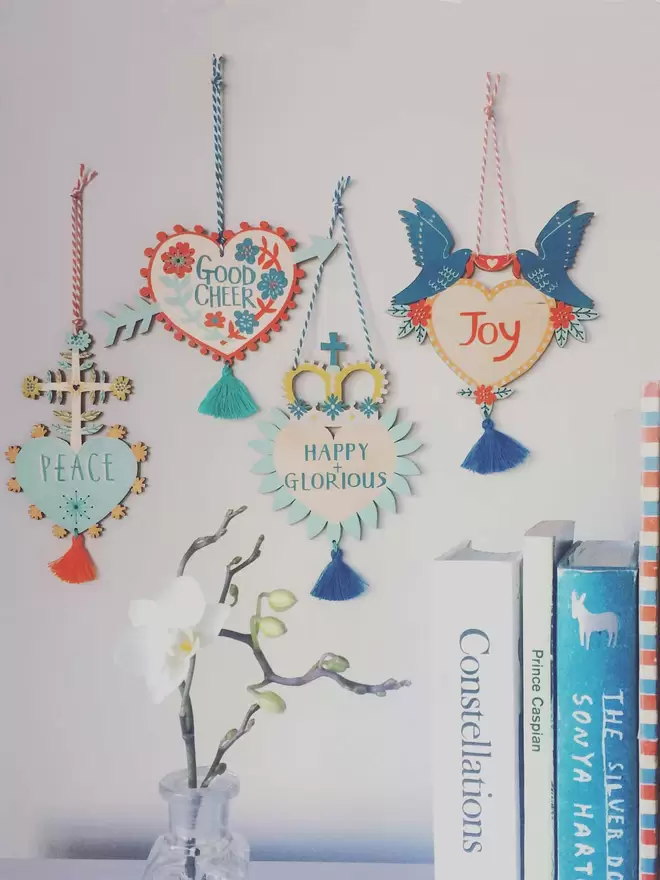 All four of the joyful Milagro charms are hung on a wall as a collection of curiosities