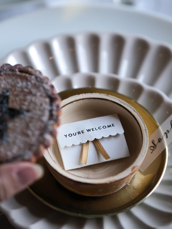A festive handpainted wooden mince pie place setting with handwriten note to welcome your guests at the Christmas table