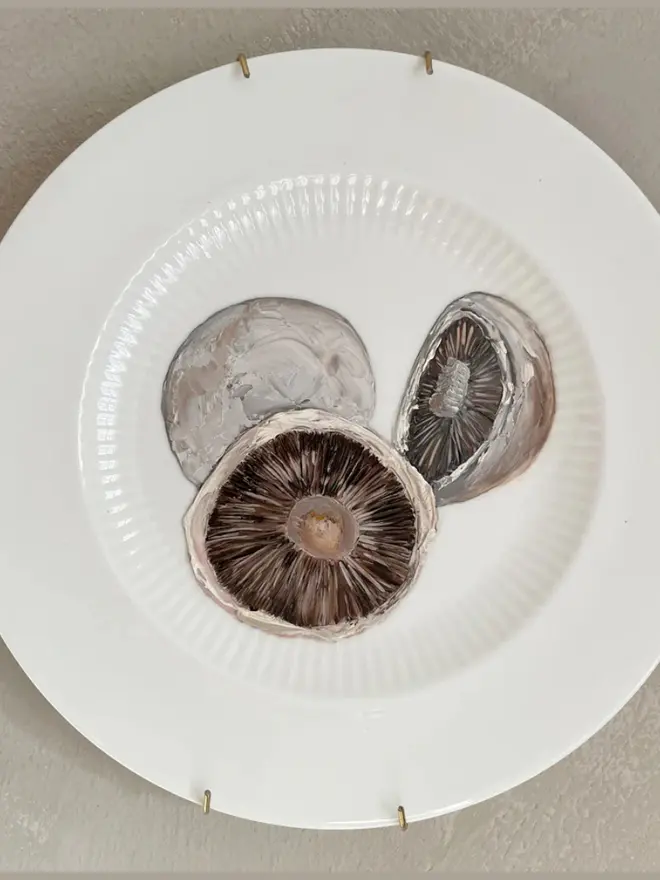 Oil Painted Breakfast Mushroom On A vintage plate, hanging in a grey wall. 