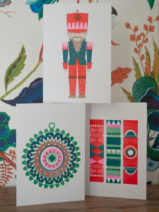 Three mini Christmas cards perfect for design enthusiasts and lovers of Scandi style. The three designs include a cute nutcracker, nordic style bauble and a fun little group of crackers. All risograph printed in bright and festive inks.