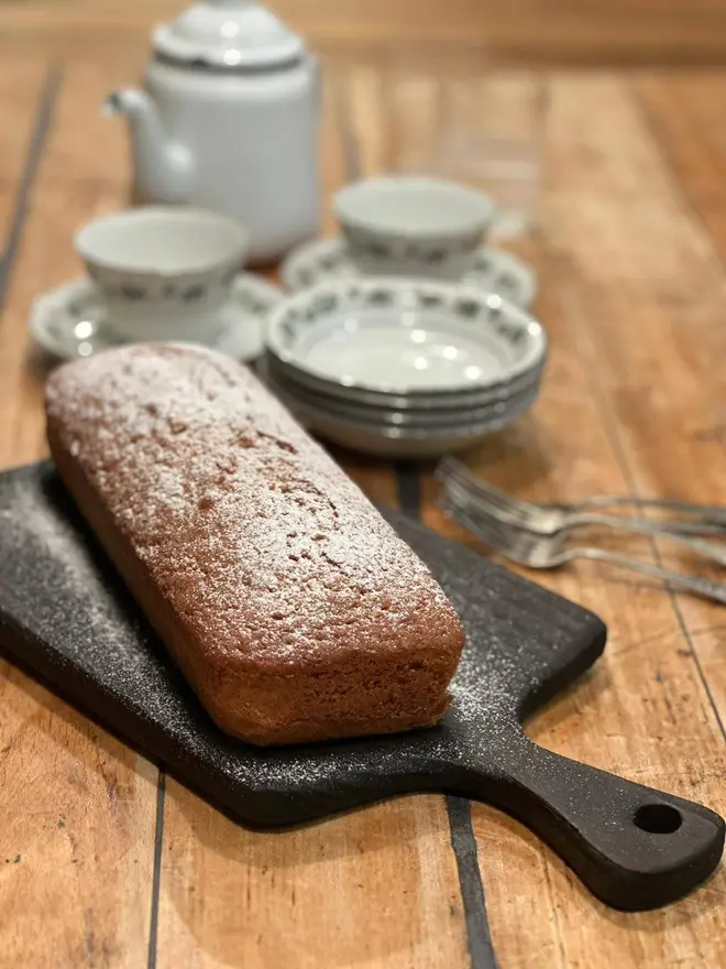 Small serving board with cake,pot of tea and cups