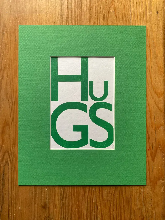 HUGS poster in green mount