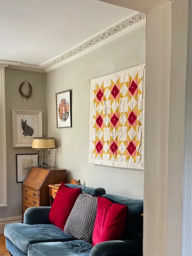 Warm Hearth Quilt Kit, hanging on the wall. 