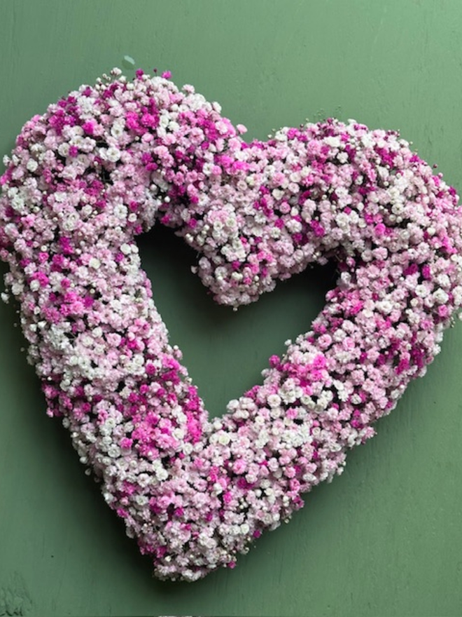 Light Pink Gypsophilia Heart Wreath against a green background