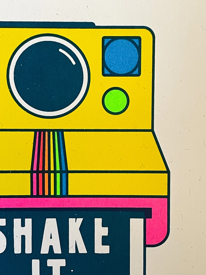 Close up photograph of a screen print featuring a poloroid camera