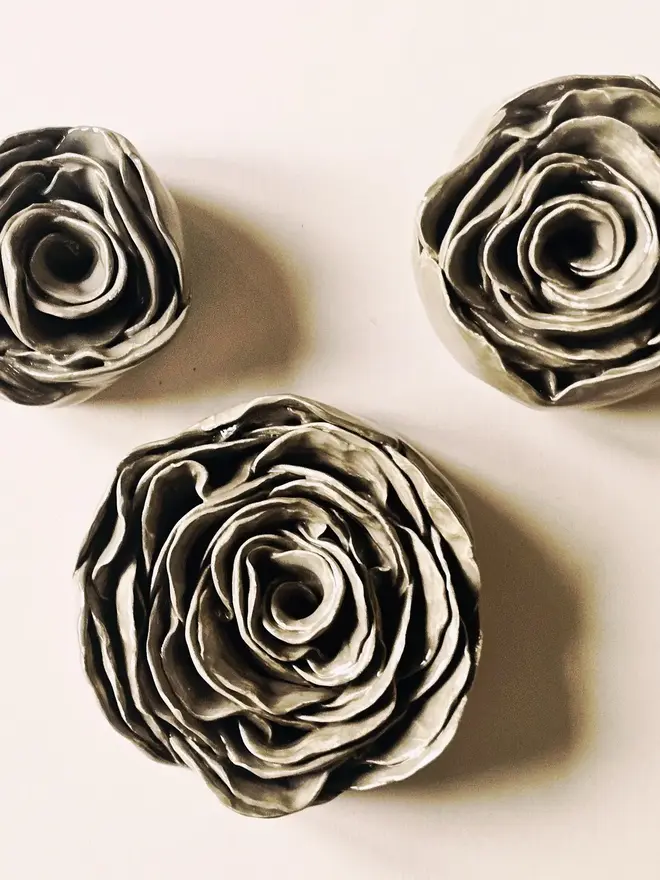 Handmade ceramic rose sculpture with a gray/greenglossy glaze, crafted in 3D and designed to hang on a wall