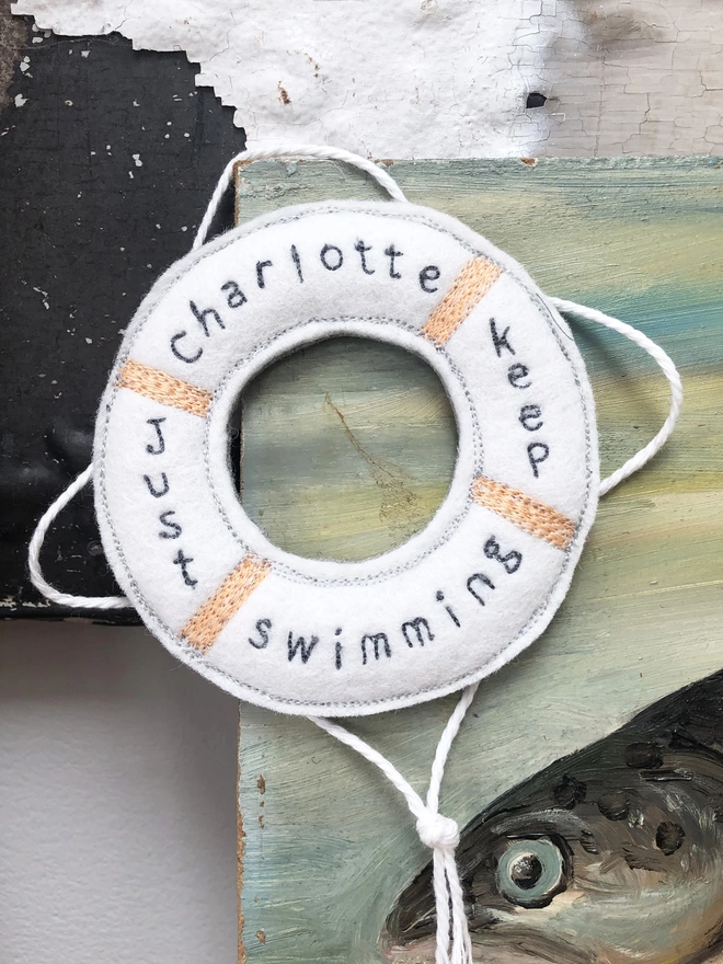 Just Keep Swimming Personalised Life Saver Ring hanging on a fish painting
