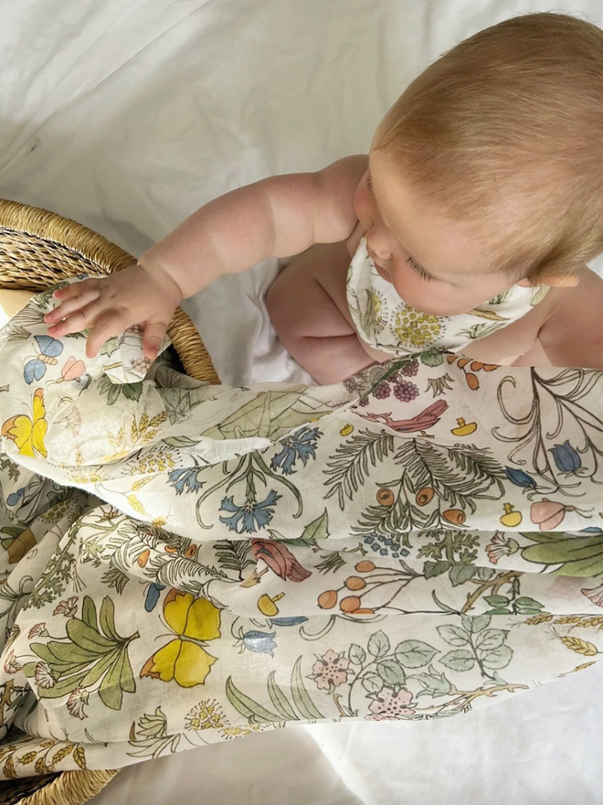 Apothecary’s Garden Muslin. A floral patterned muslin with a baby.
